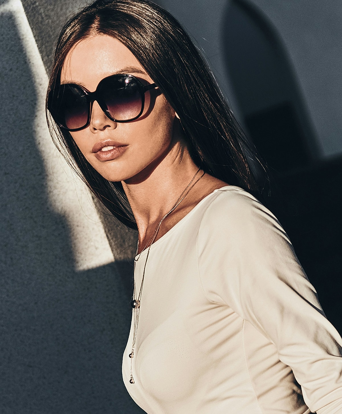 Woman in oversized sunglasses and stylish outfit.