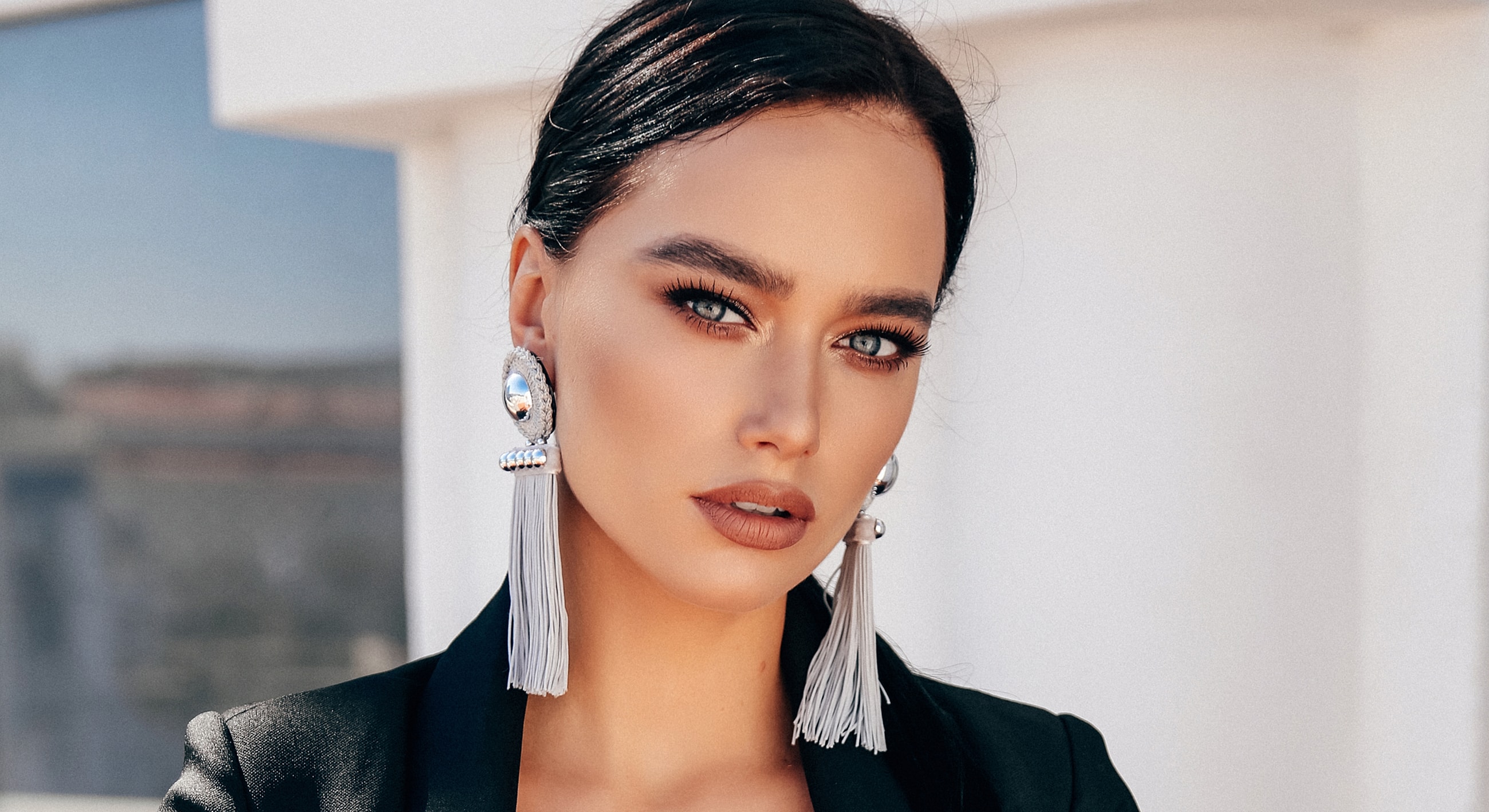 Woman with stylish earrings and elegant makeup.