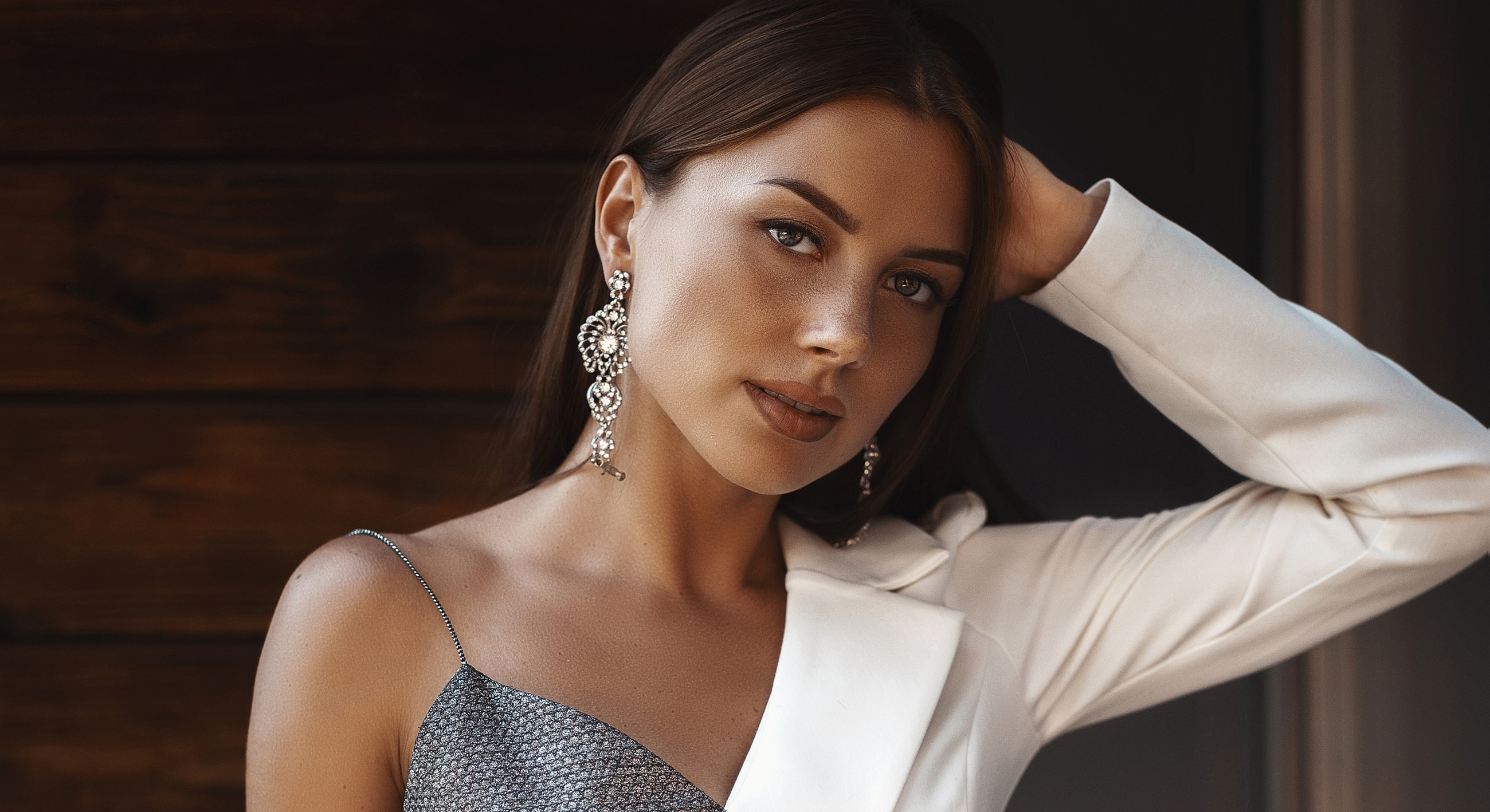 Woman with statement earrings and stylish outfit.